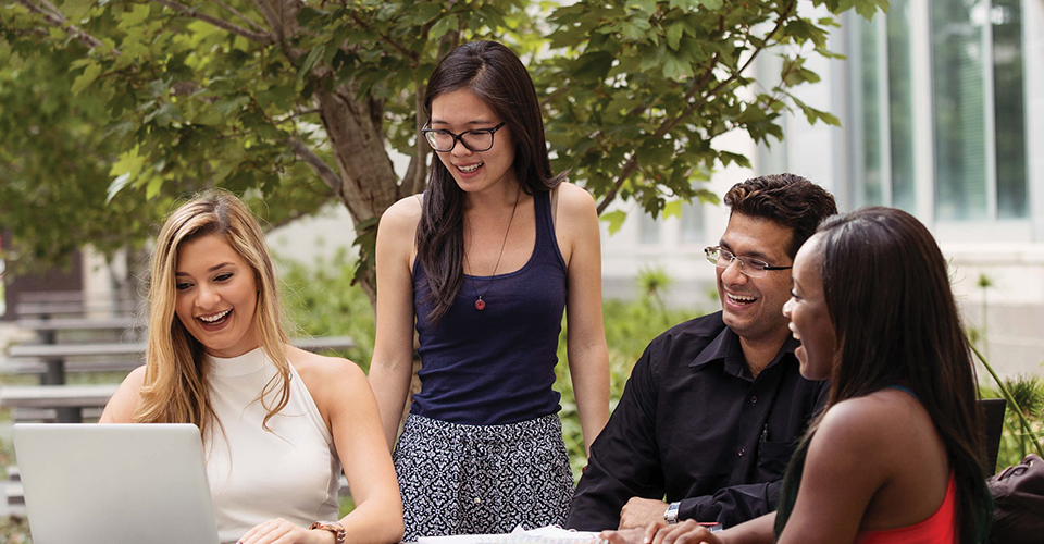 group of students collaborating at an outdoor table